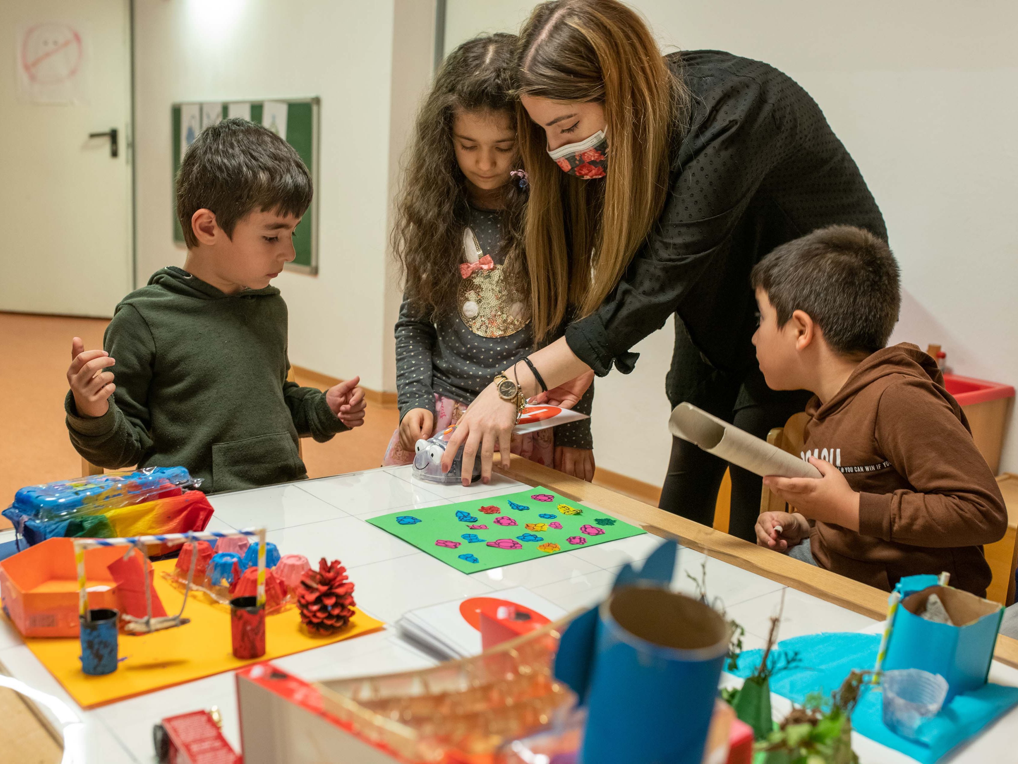 Kinder tüfteln mit der Unterstützung einer Mitarbeiterin im Kindermuseum Mondo mio