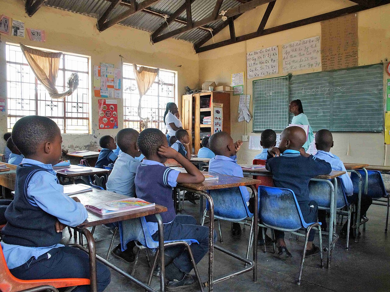 Grundschulkinder der Gemeinde Welverdiend in Südafrika sitzen blauer Schuluniform in einem Klassenraum