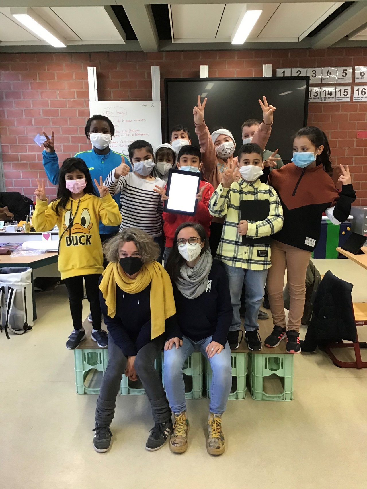 Kinder der Diesterweggrundschule in ihrem Klassenraum auf einem Gruppenfoto mit zwei Lehrerinnen